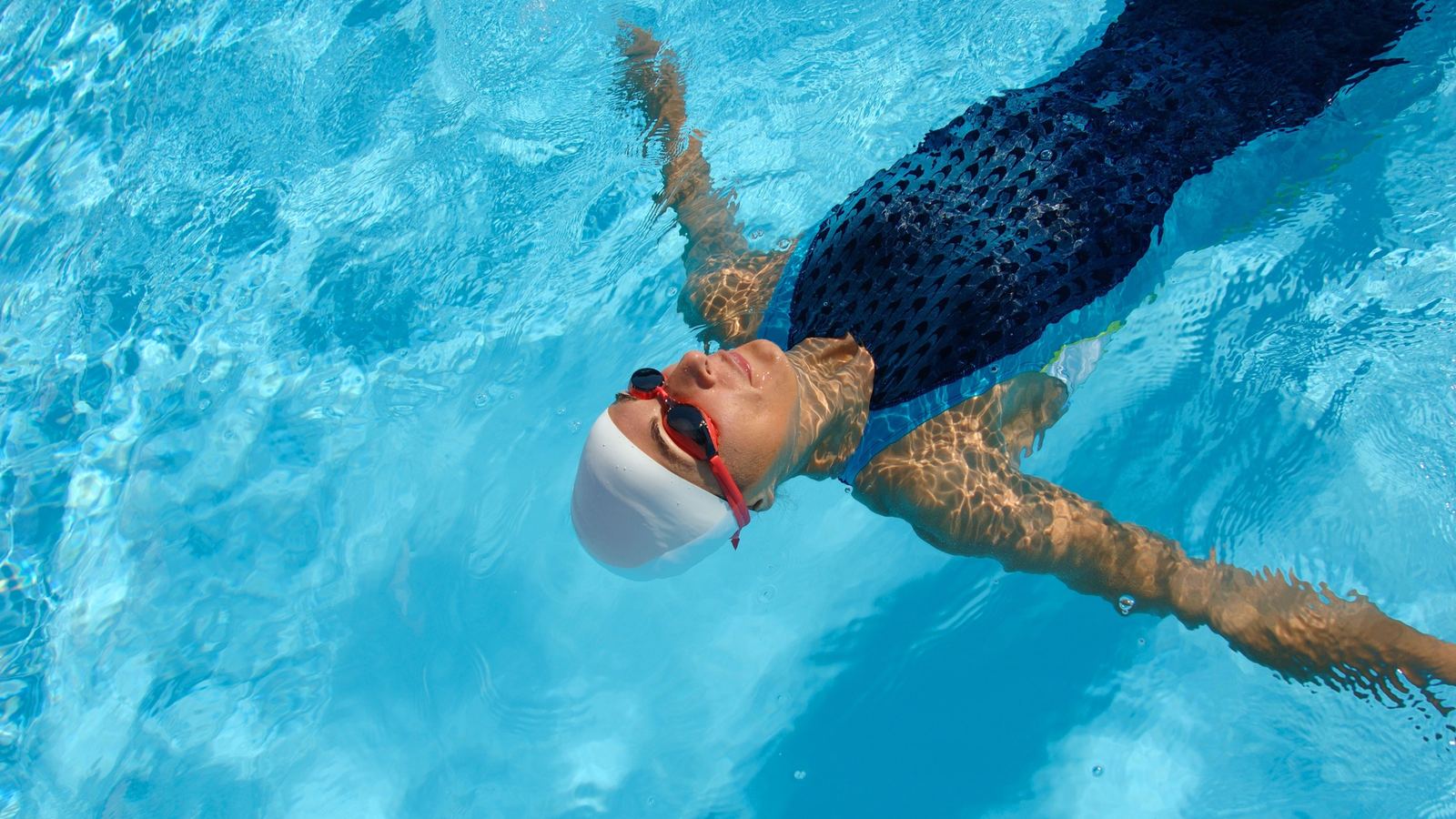 An adult swimmer mid-freestyle stroke